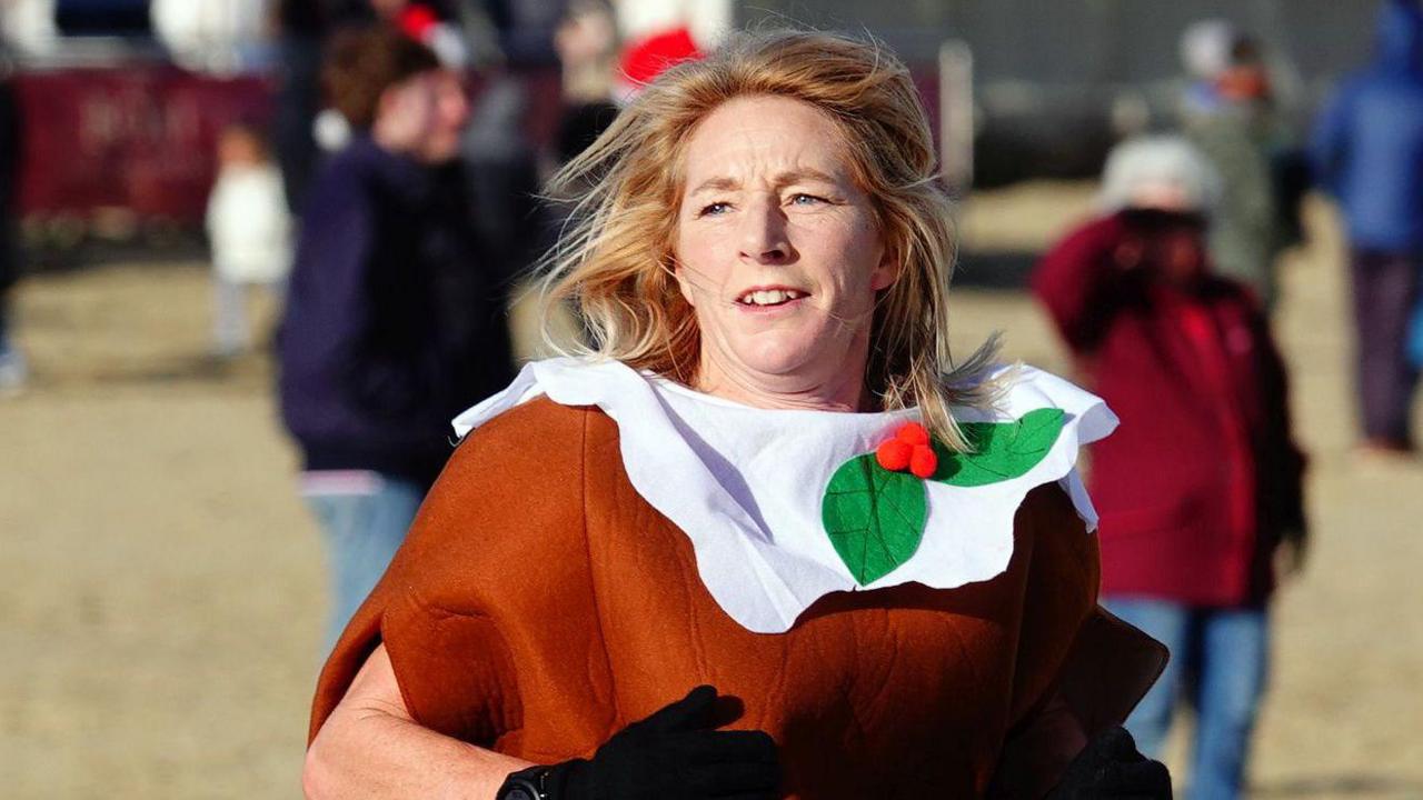 A woman dressed as a Christmas pudding