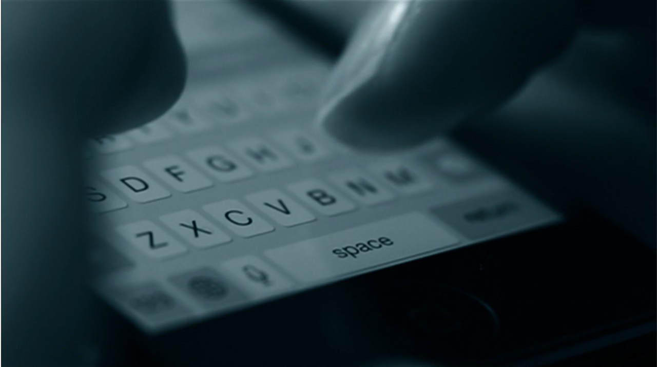 A black and white photo of a person's hands typing on a mobile phone