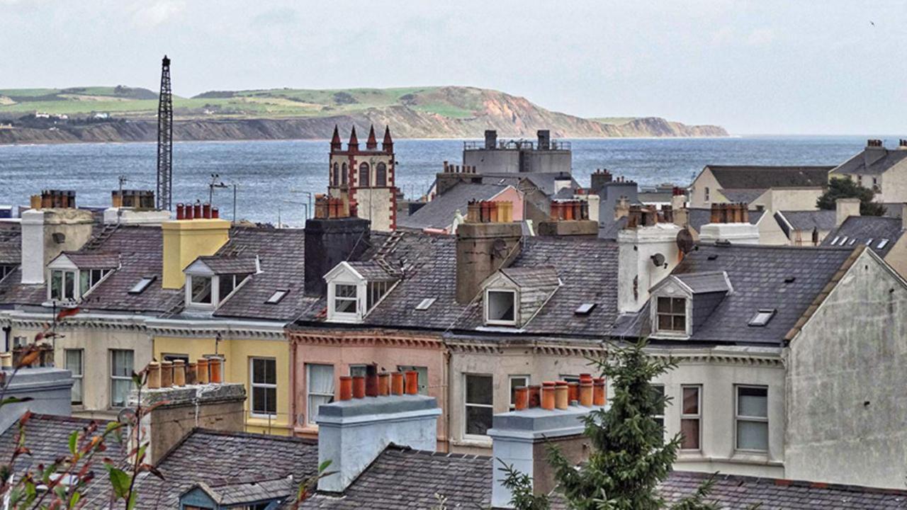 Rooftops in Ramsey with Ramsey Bay and the sand cliffs and hills in Bride in the background.