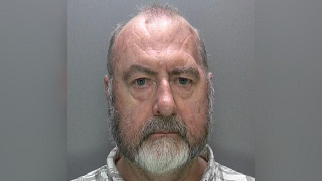 A police mugshot of Ivor Whittaker in which he is looking at the camera and a pale checked shirt can just be seen. He has a grey and white beard