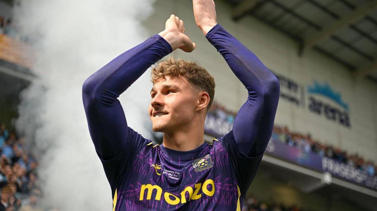 Carl Rushworth claps Coventry supporters on the final day of the season, wearing a purple goalkeeper jersey 