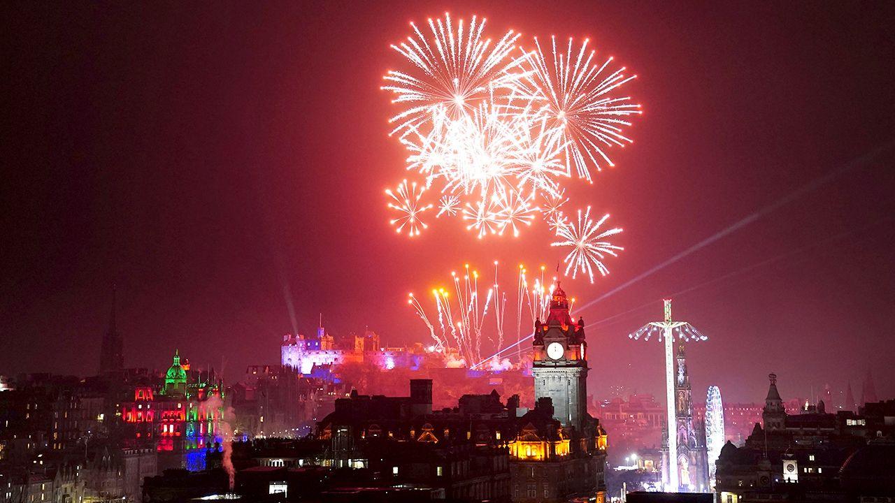 Hogmanay celebrations in Edinburgh. Firework displays can be seen behind Edinburgh Castle.