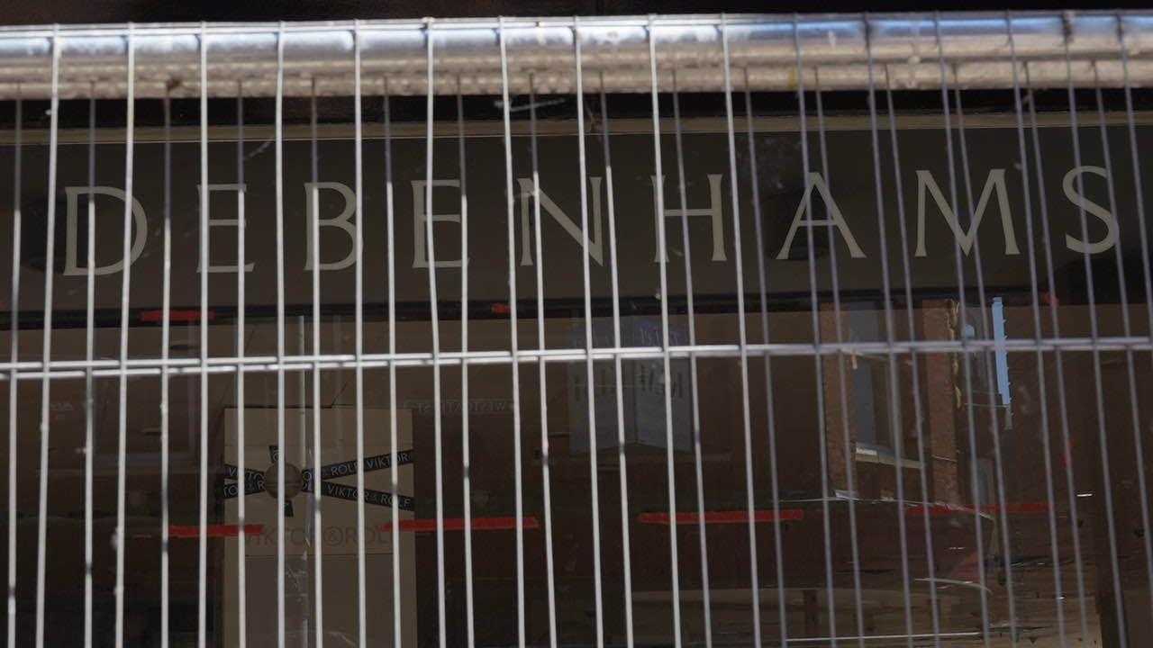 The front of a Debenhams store behind Heras fencing.