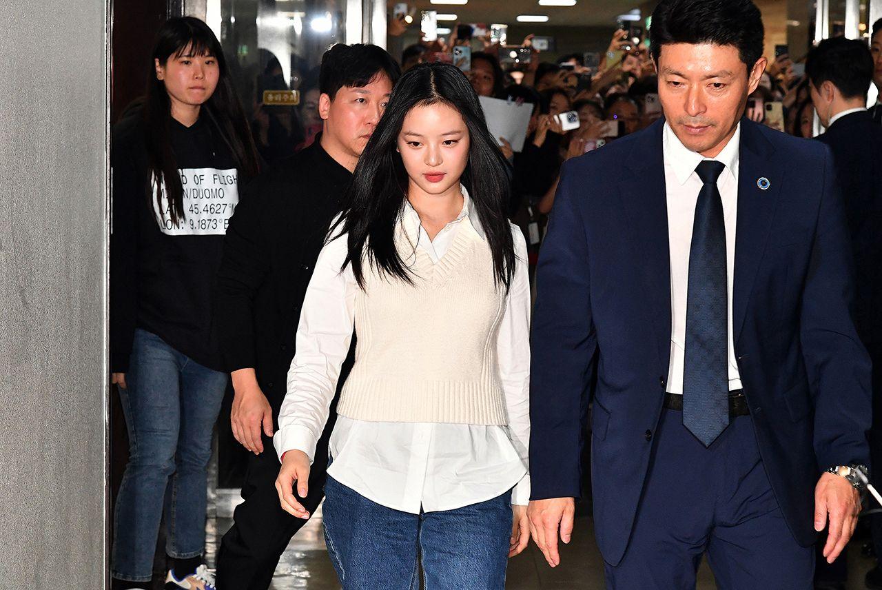 New Jeans' Hanni walks alongside a man in a suit as she arrives to testify at the National Assembly for hearing on October 15, 2024 in Seoul, South Korea