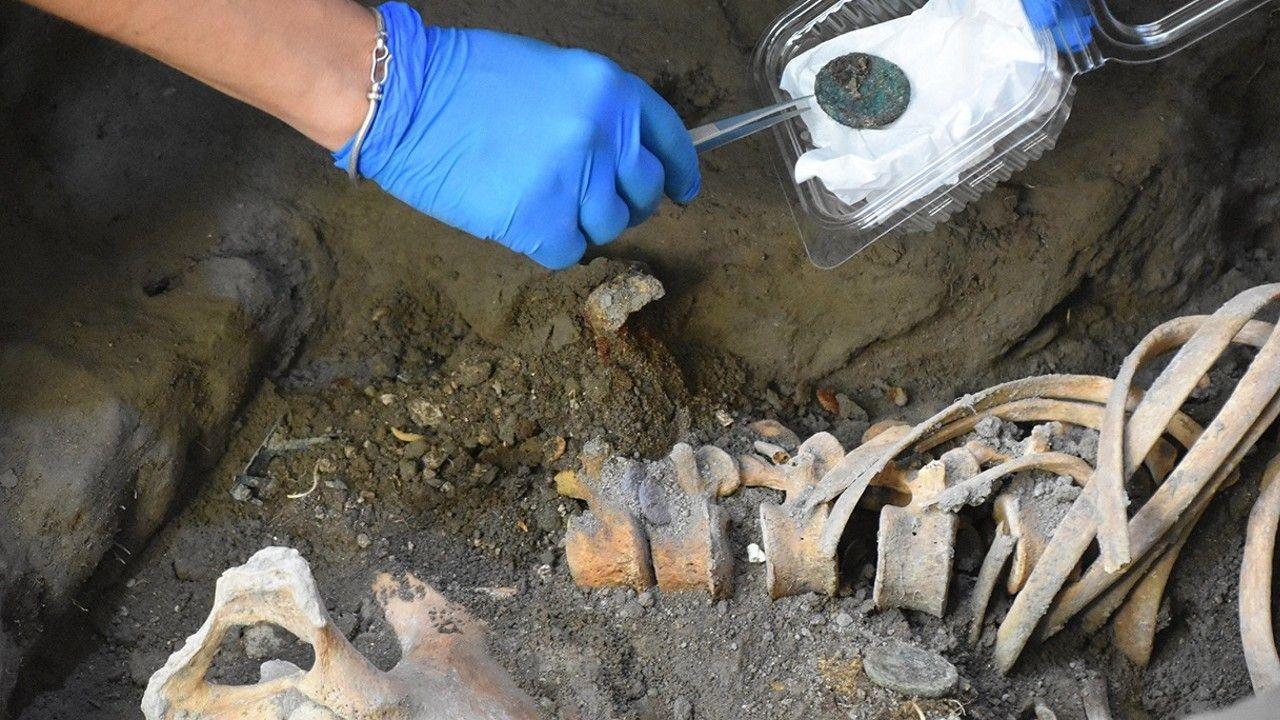 Archaeologist's hand with remains and artefacts on Pompeii site.