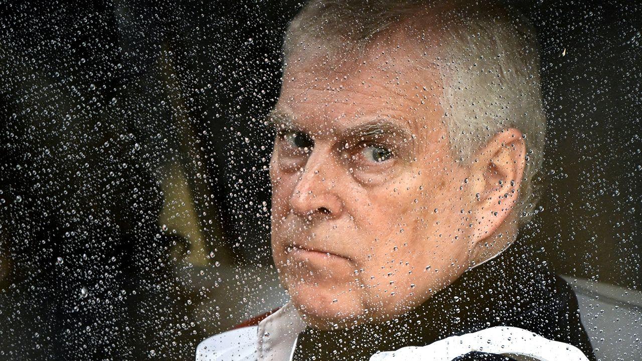 A close-up shows Prince Andrews head and shoulders as he looks out of a car window on a rainy day. He is looking off to his left, and scowling at the camera. Image taken as he leaves Westminster Abbey following the coronation ceremony of Britain's King Charles and Queen Camilla in May 2023.