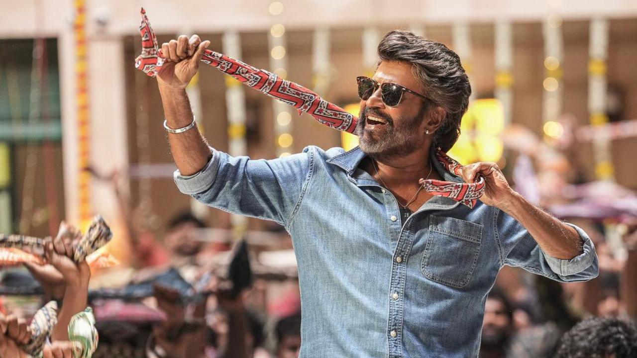 Rajnikanth, an Indian film star, wearing a blue shirt and a colourful scarf around his neck