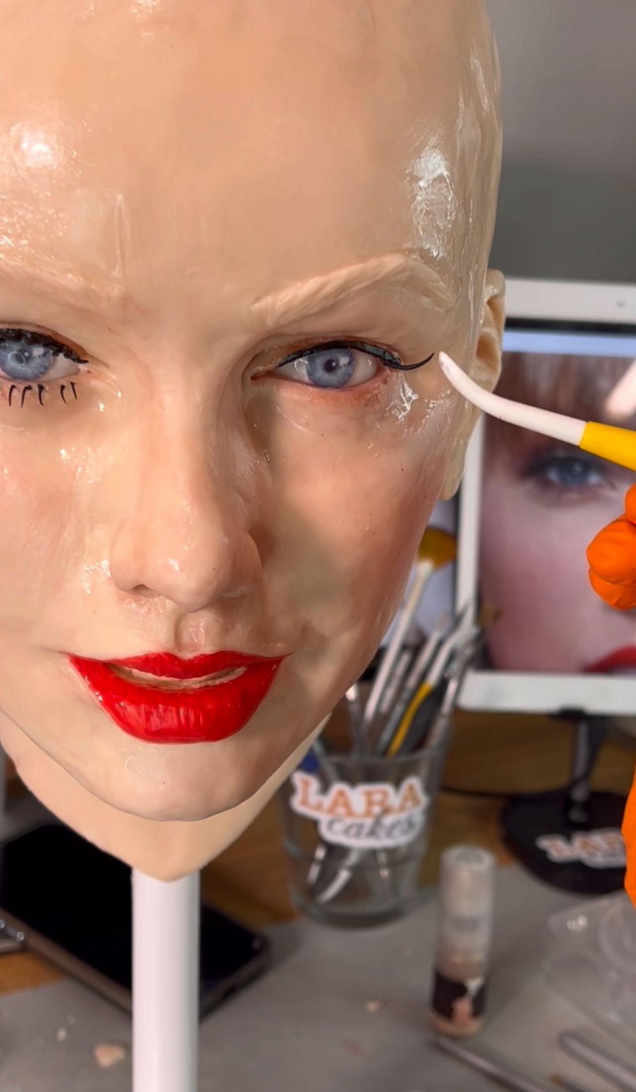 A brush works on the replica of Taylor Swift's face