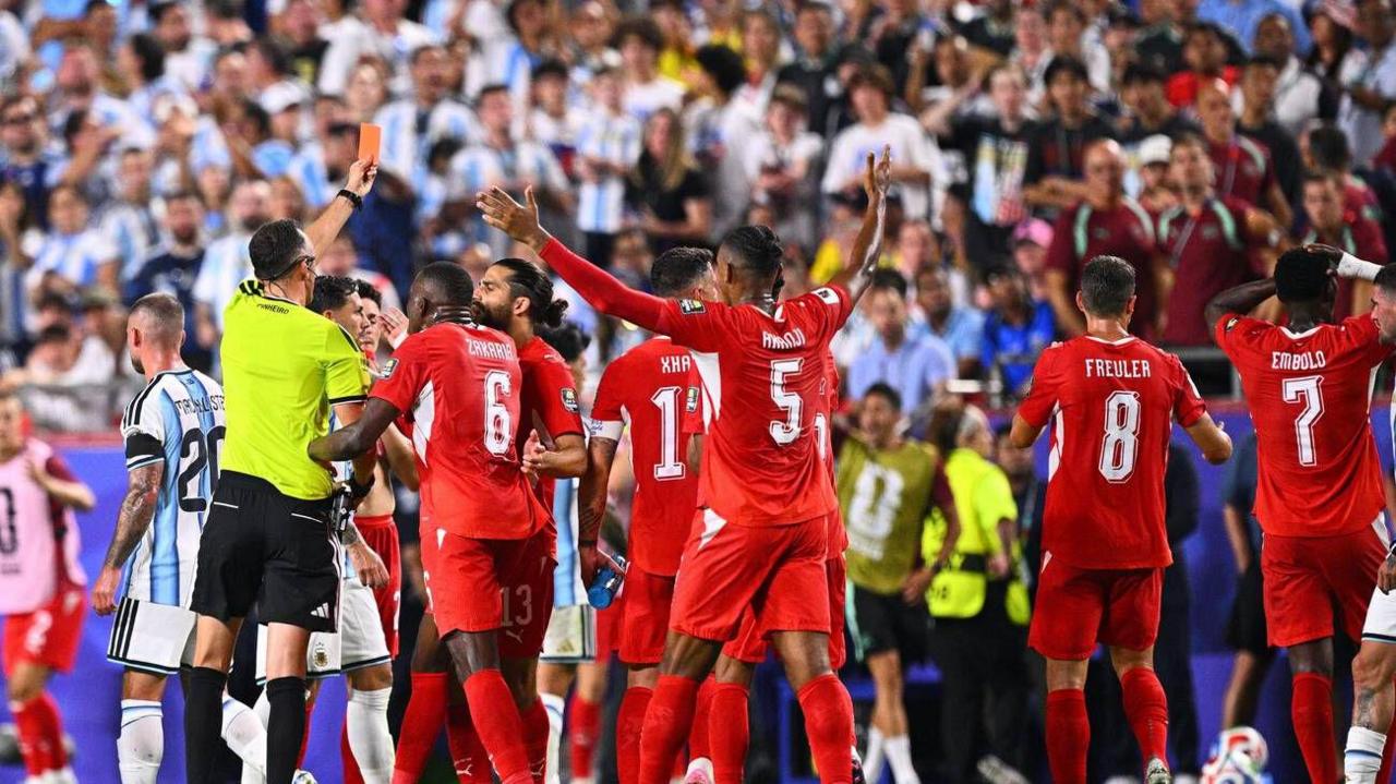 El árbitro le muestra la tarjeta roja a un consternado Breel Embolo, quien tiene ambas manos en la cabeza, dándole la espalda al árbitro.