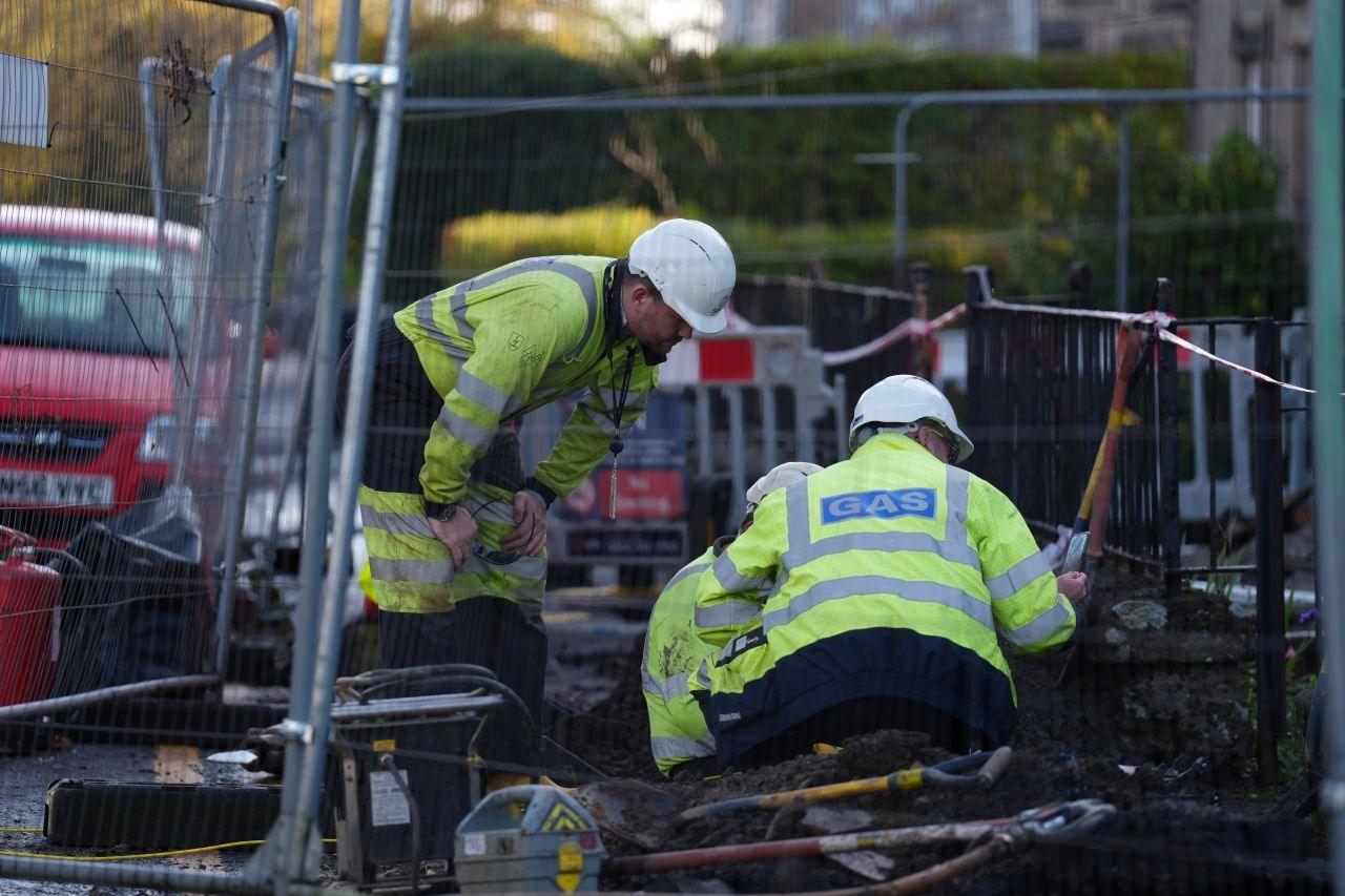 Two men wearing hard hats and tabards with the word Gas written on the back.