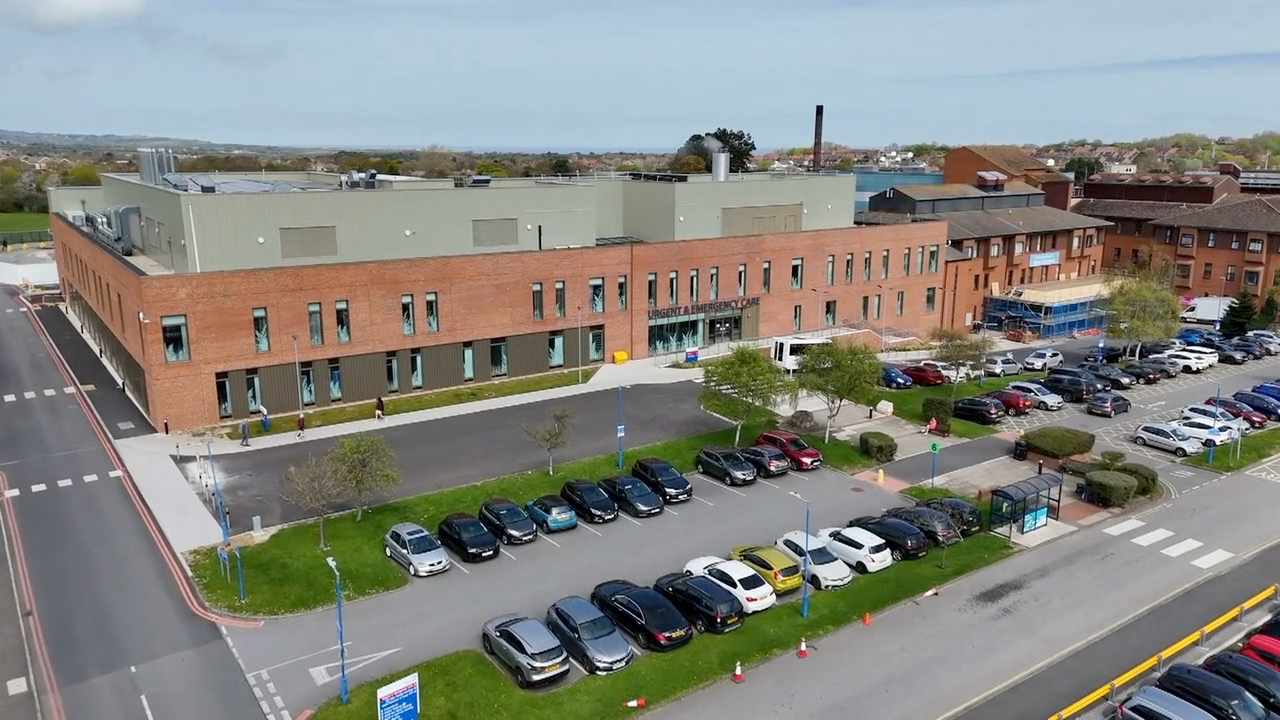 A bird's eye view of the new Urgent and Emergency Care Centre at Scarborough Hospital. It is a large two-storey building, which has a car park in front of it. The photograph has been taken by a drone.