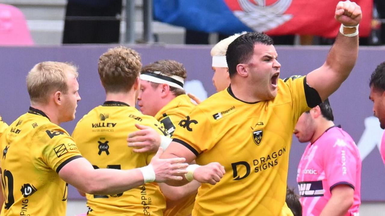 Dragons players including Chris Coleman (R) celebrate a try against Stade Francais
