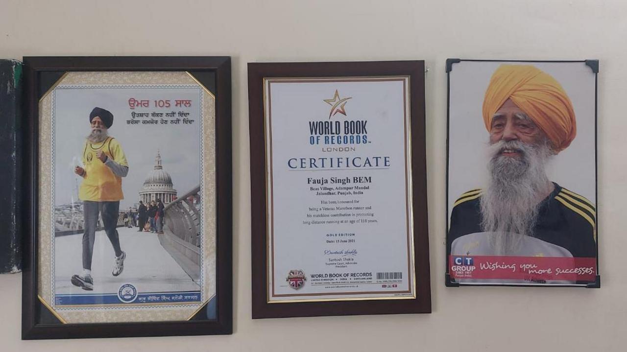 A wall with Singh's certificates and photos.