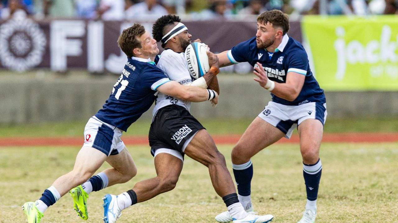George Horne and Ollie Smith try to stop an advancing Fijian