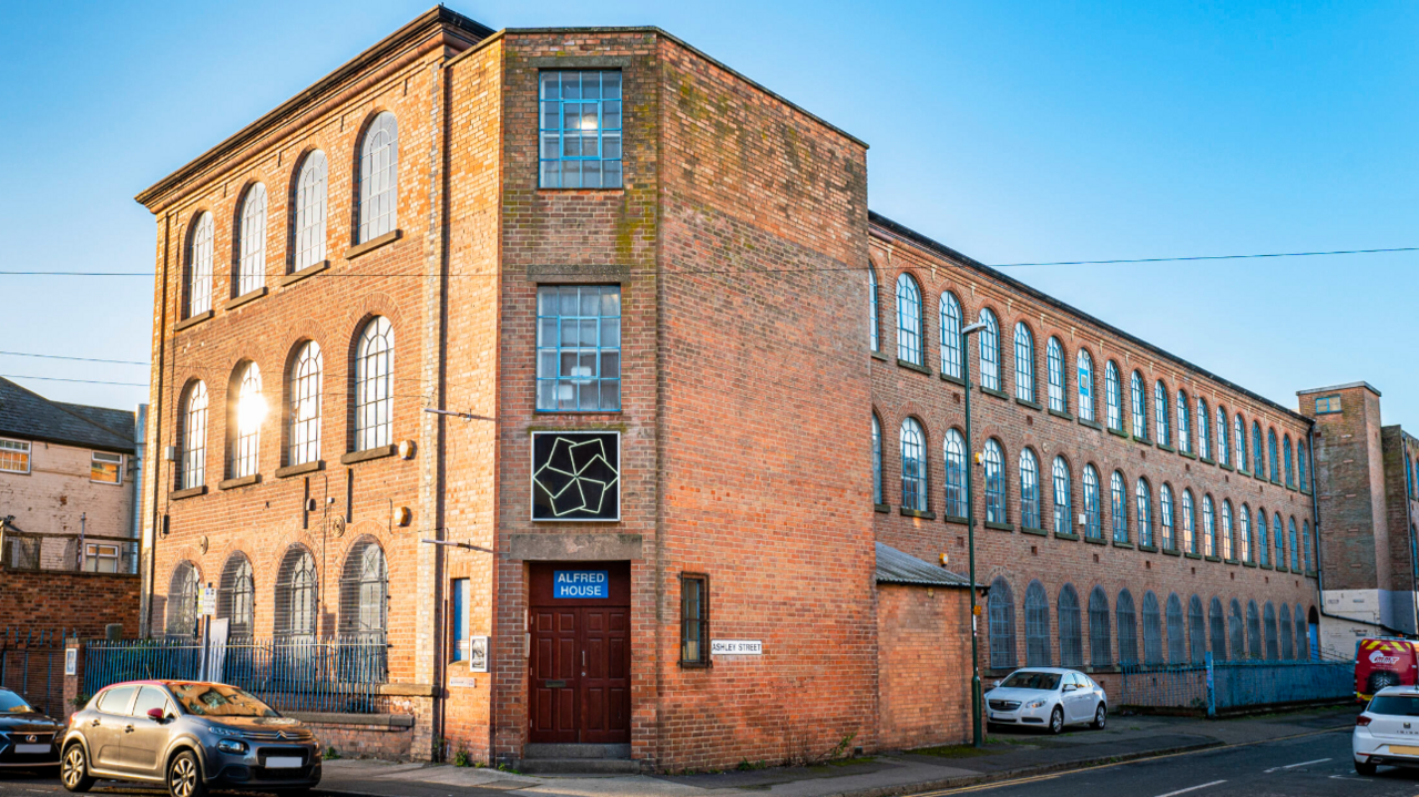 A large three-storey brick factory building with many windows