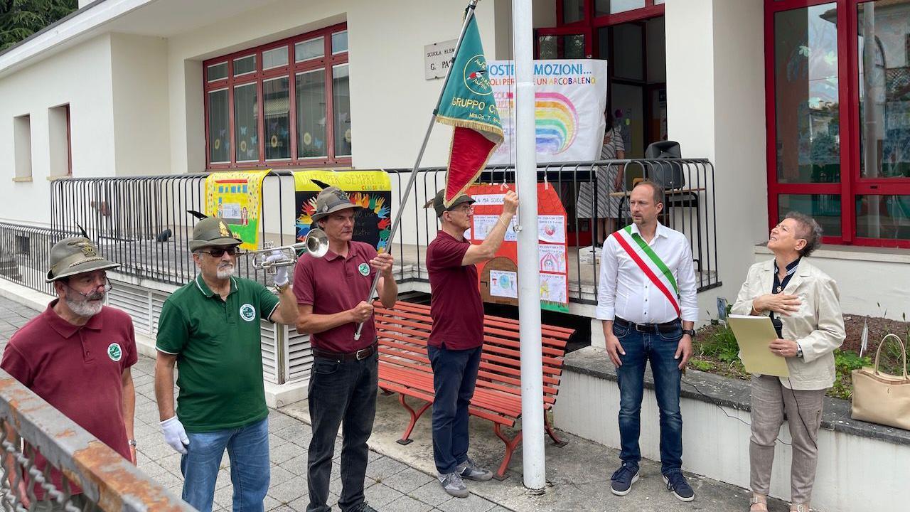 School closing ceremony - men in Alpine hats hold a flag and a bugle
