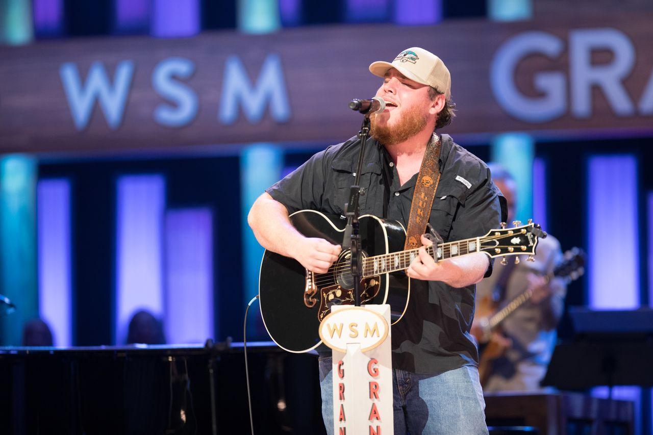 Combs strums a guitar on stage at his Grand Ole Opry debut in 2016 in Nashville, Tennessee