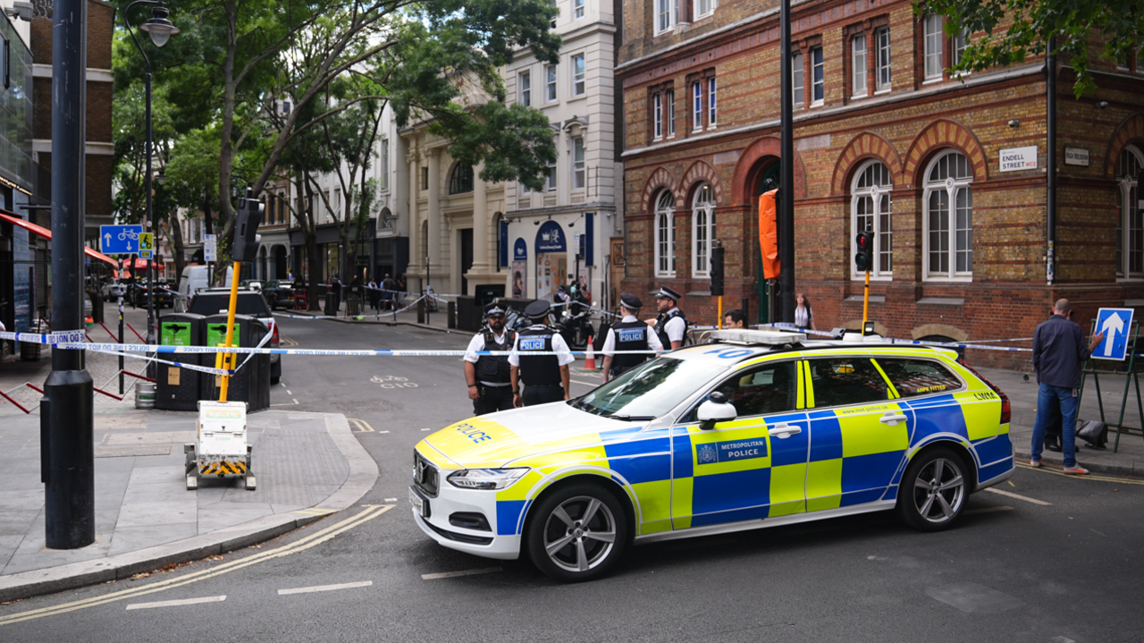 Police officers stand around a cordon with a police vehicle Endell Street in Covent Garden, central London