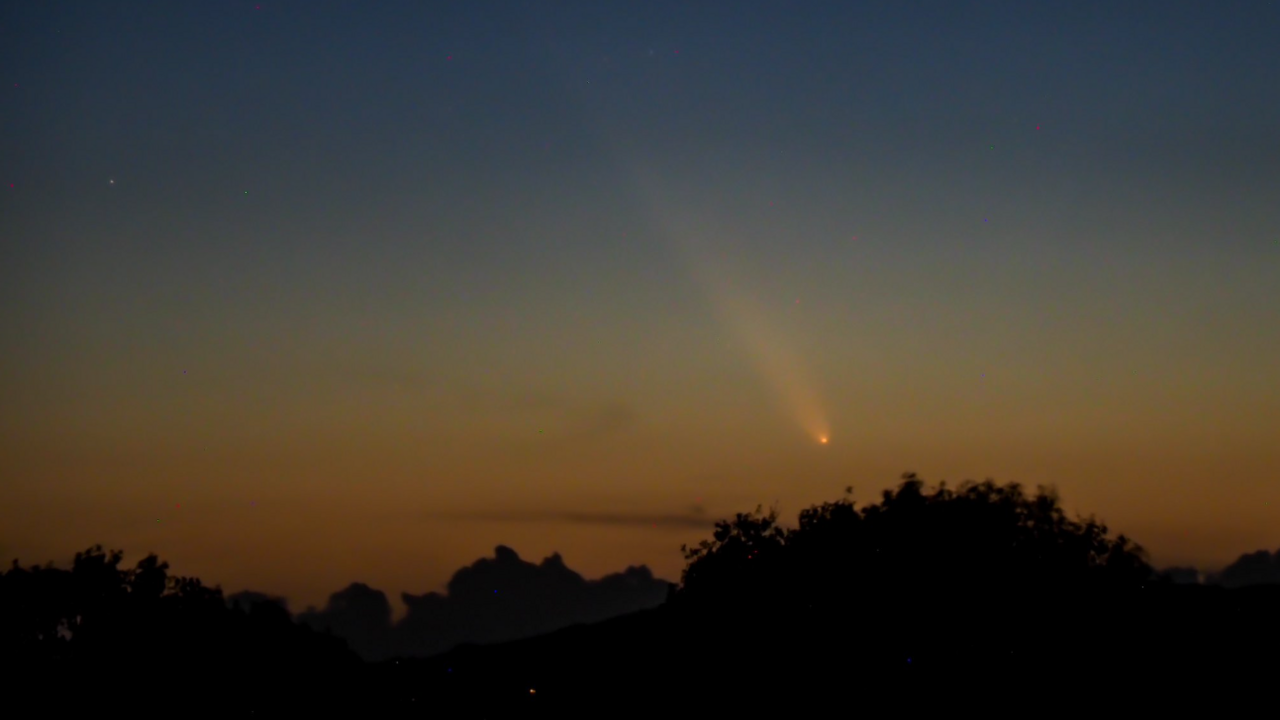 The comet is flying through the sky, apparently towards some trees, during the end of a sunset in Kinver, Staffordshire.