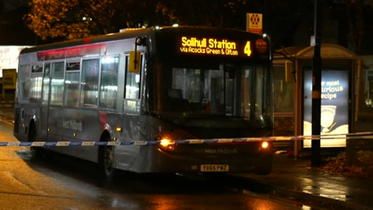 A single decker West Midlands bus pulled up by a bus stop at night, with police tape placed in front of it. The destination display shows it is a number 4 bus heading for Solihull Station.