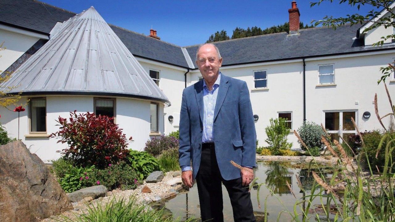 Jake Honeybill standing in the gardens of Les Bourgs Hospice 