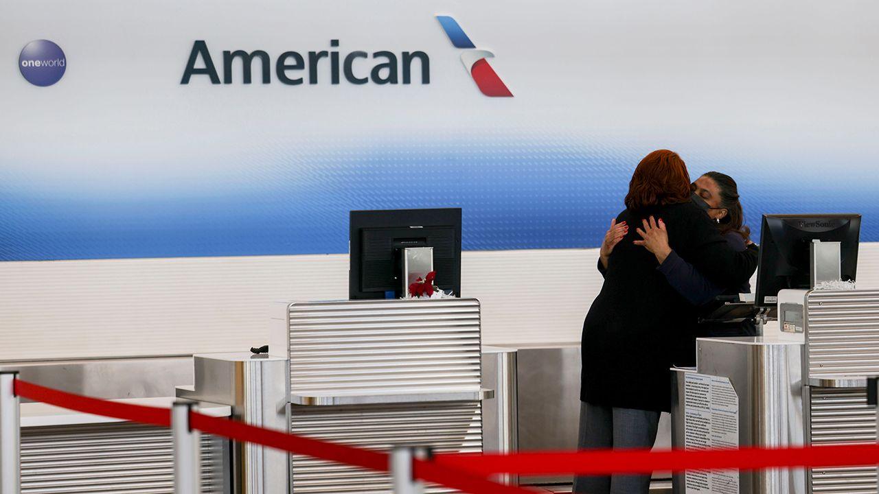 Employees embrace at the American Airlines counter at Ronald Reagan National Airport after a nearby air crash