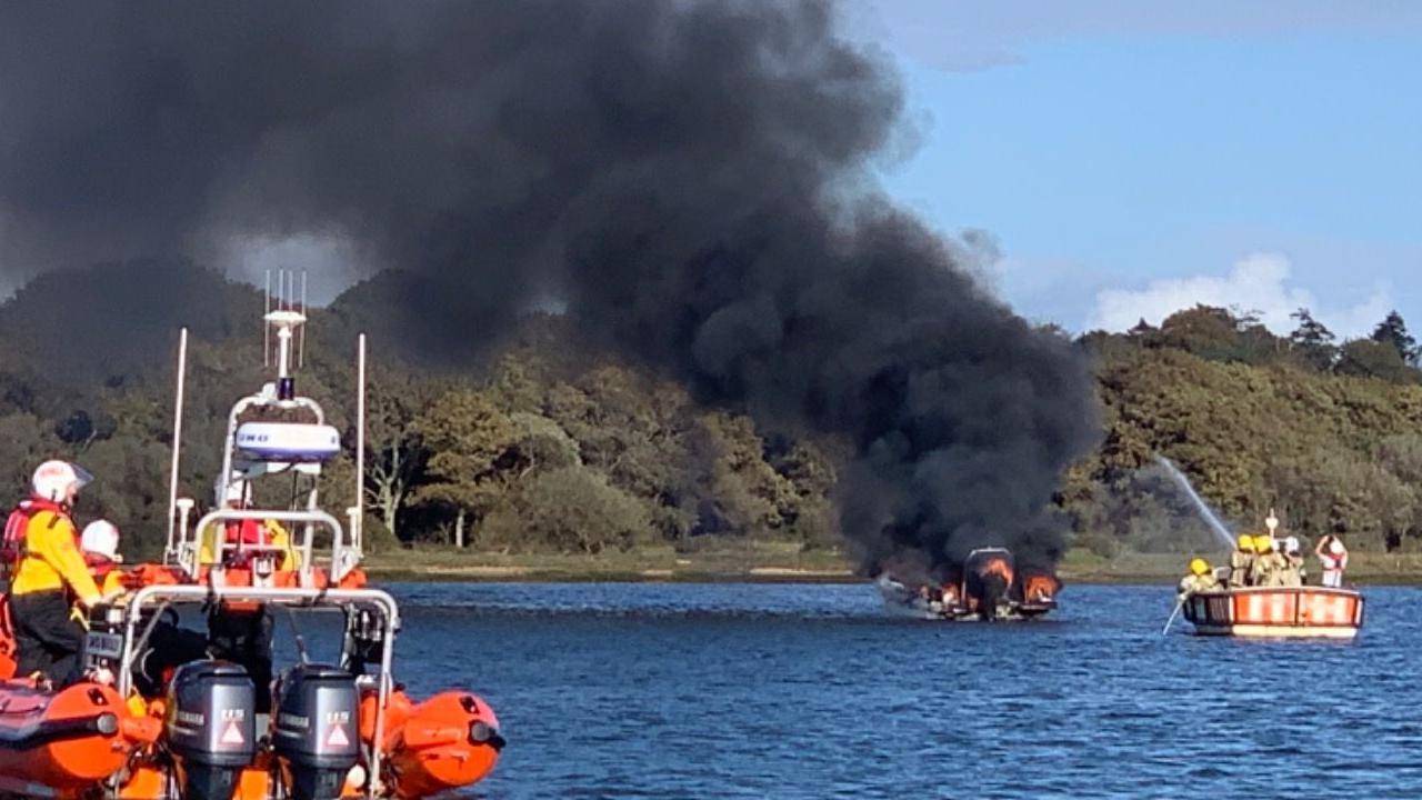 Firefighters and coastguard teams helping to put out the fire on the boat