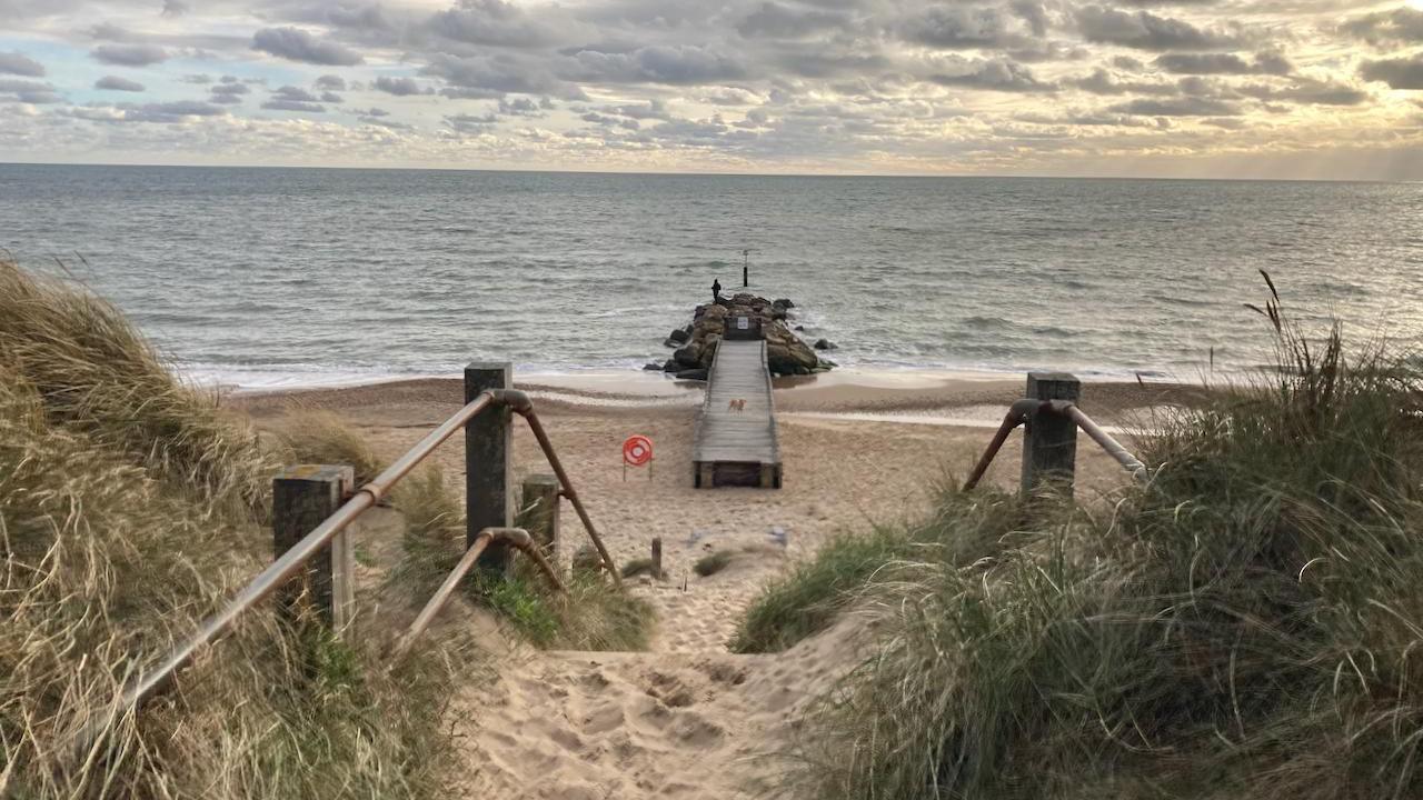 Southbourne beach in Bournemouth with a boadwalk leading off a beach into the sea