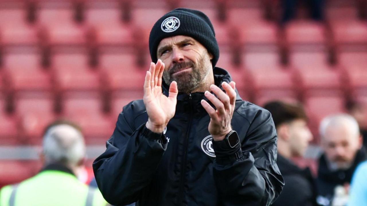 Paul Warne applauds the MK Dons supporters after their win at Crewe.