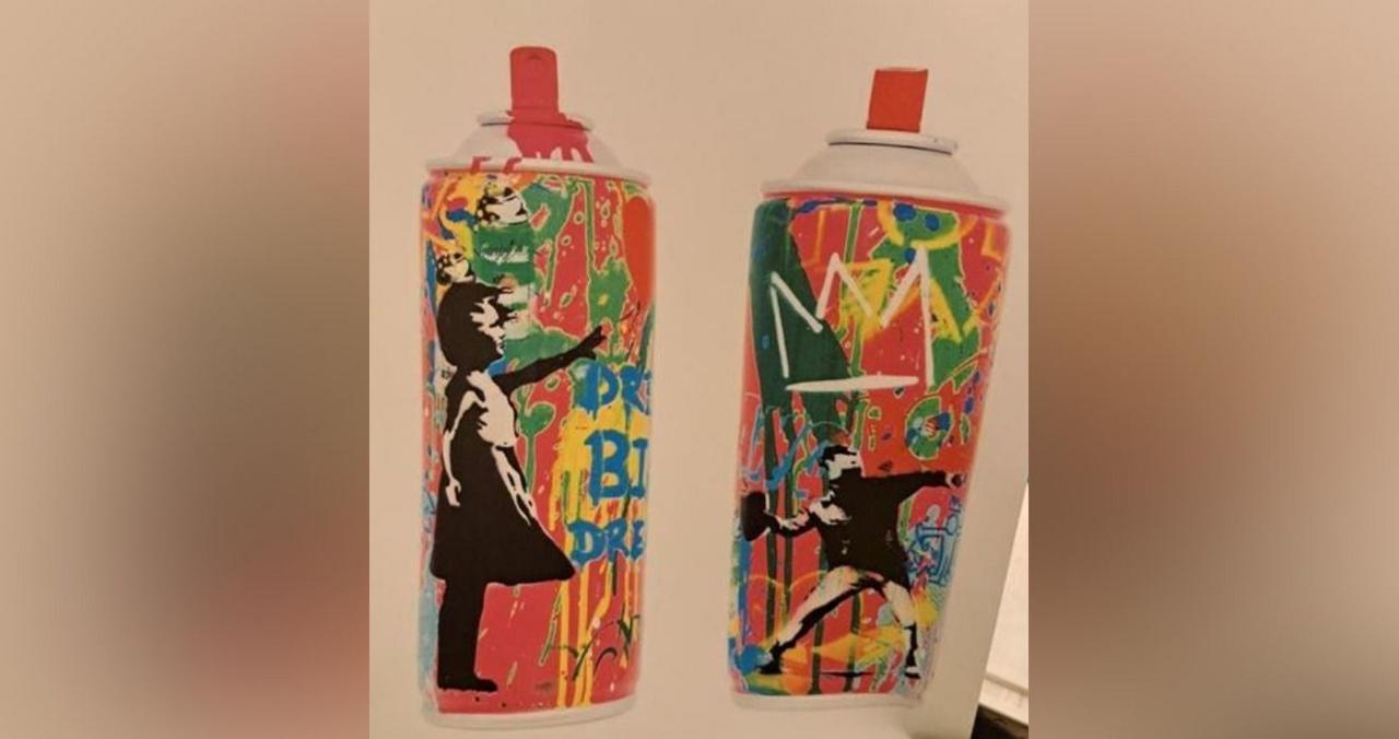 Two pictures of different sides of a spray paint can. It has a red top and is pink with a girl and green paint splotches on one side and a man throwing something with various other blue yellow and white paint blotches and drips on the other.