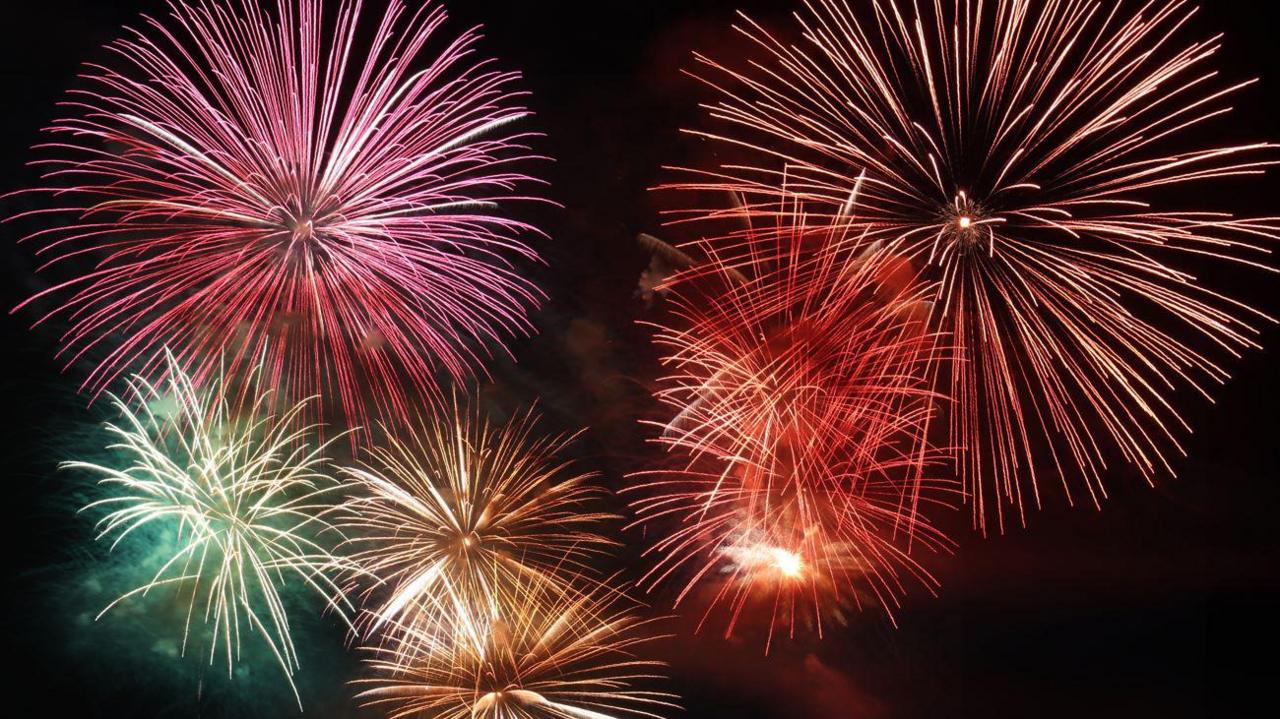 A number of large fireworks explosions in different colours