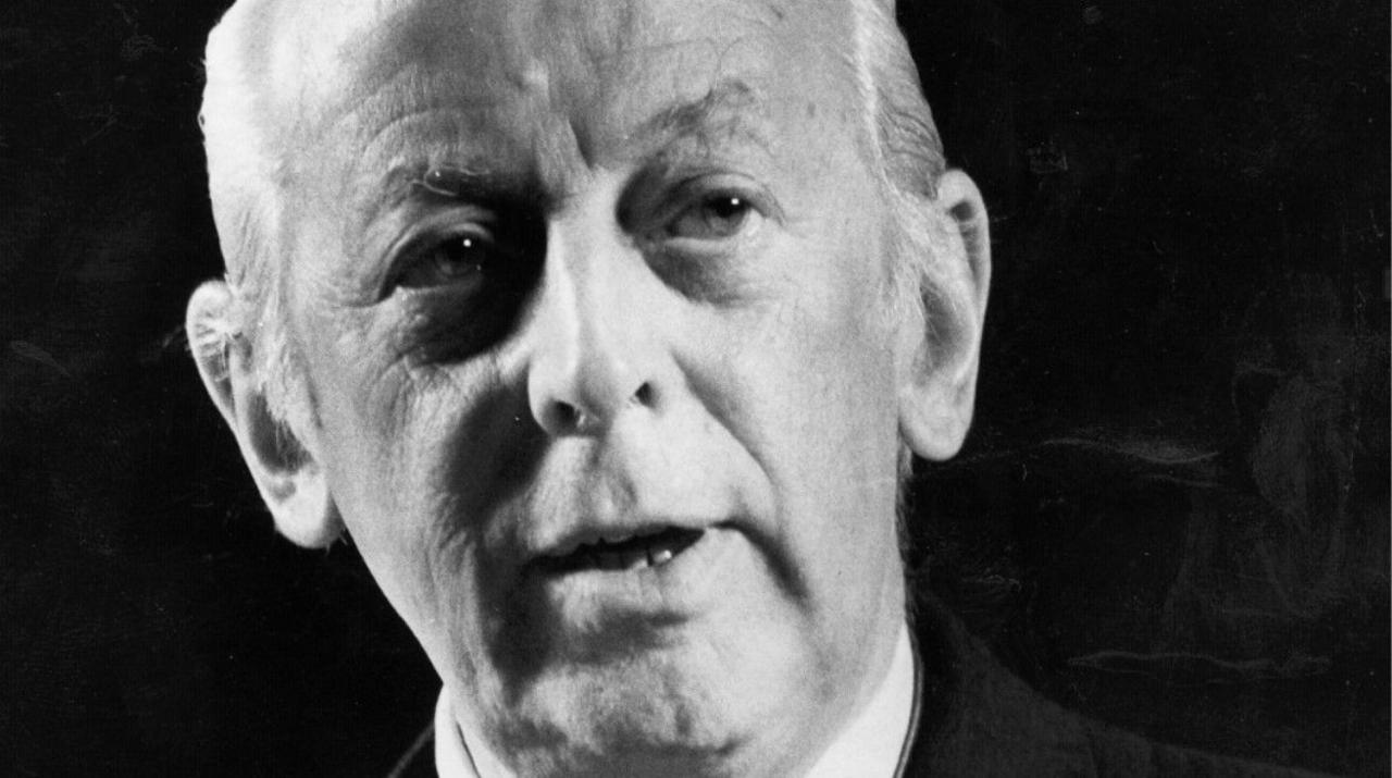 Black and white archive shot of Alistair Cooke.