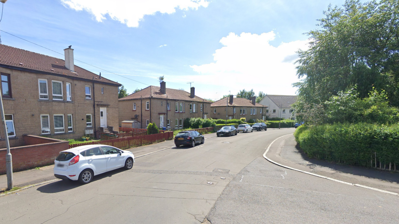 Google maps screengrab of Curzon Street in Ruchill. No particular property is the focus of the image. There are five cars parked on the streets and a hedge and some trees on the left.