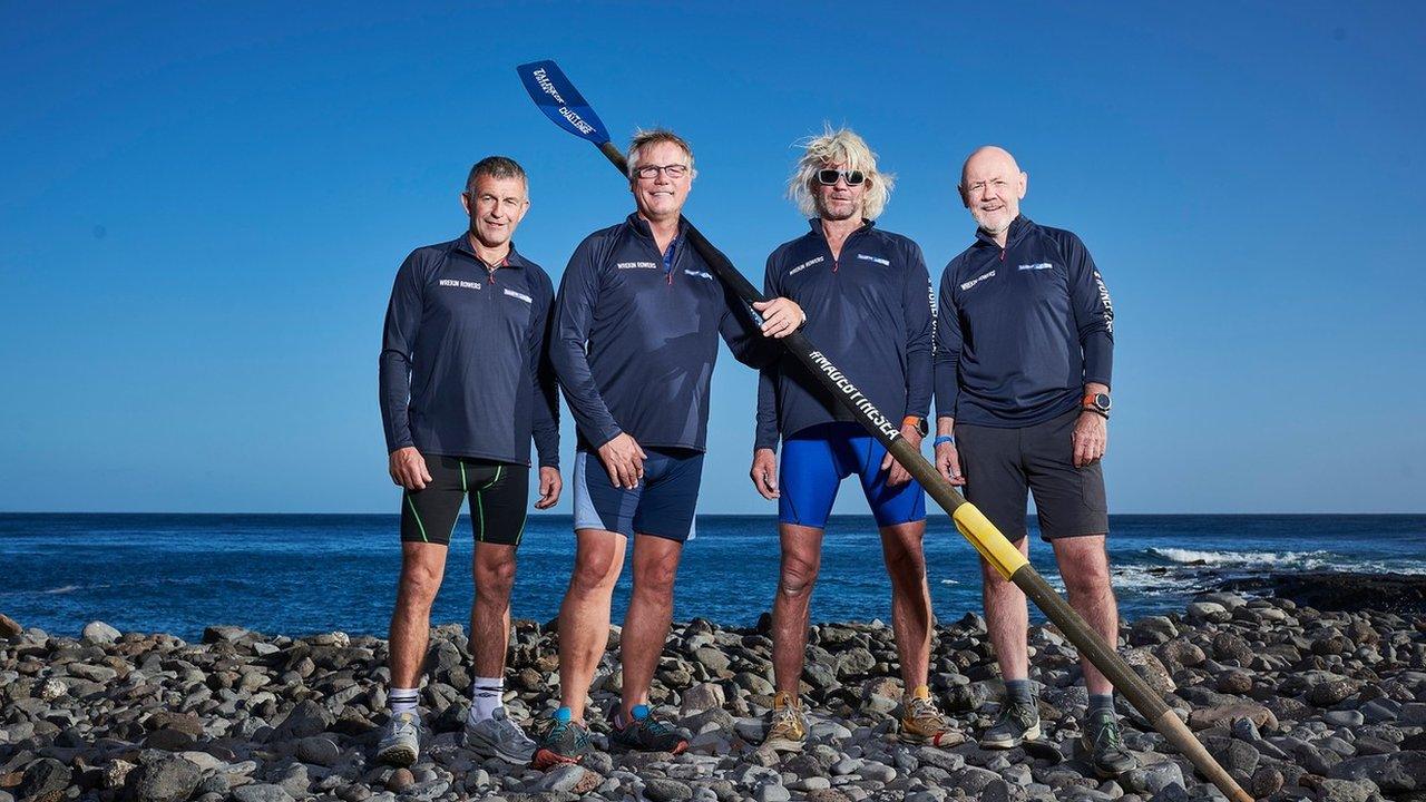 Four men standing on a beach