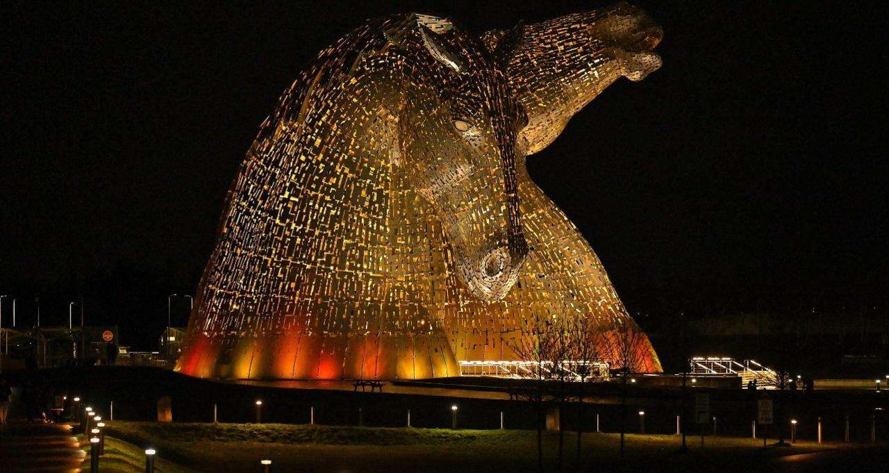 The Kelpies in Falkirk, Central Scotland, as they are lit up yellow.