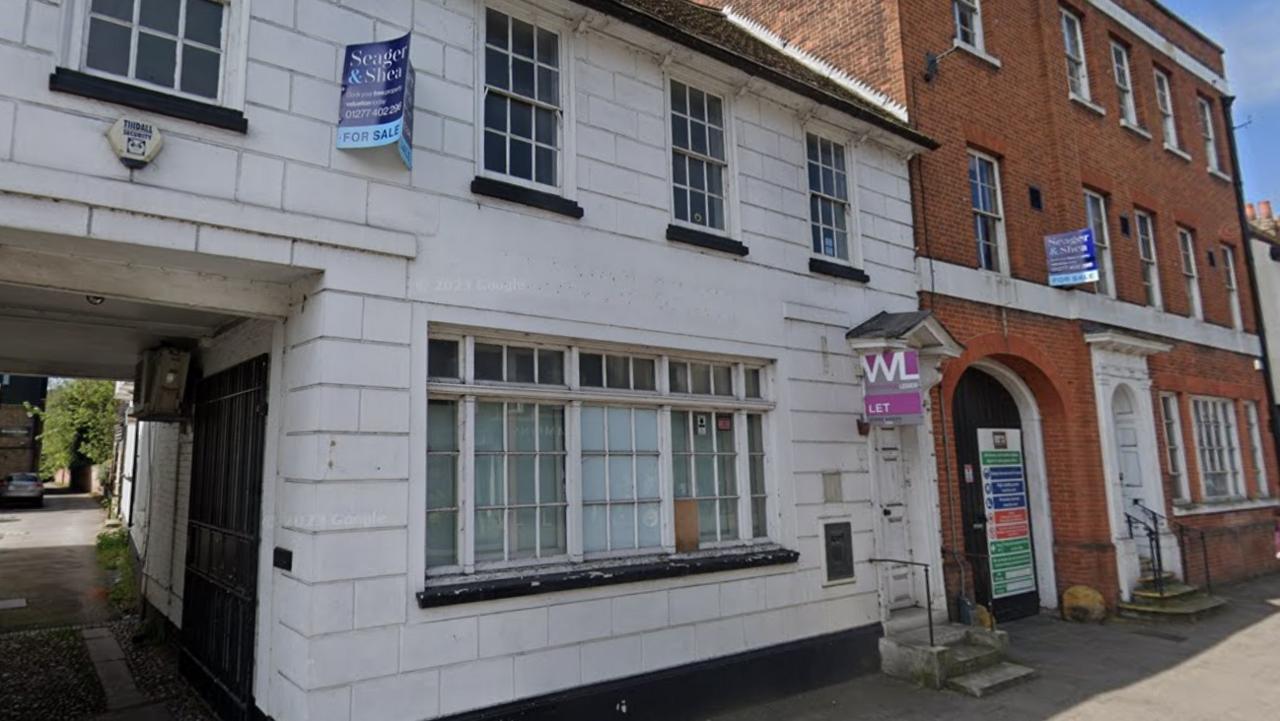 Two closed down buildings with boarded up windows and doors