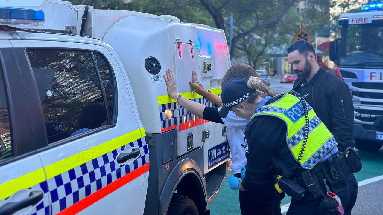 A climate activist is arrested for the forced evacuation of Woodside Energy's Perth headquarters on 1 June