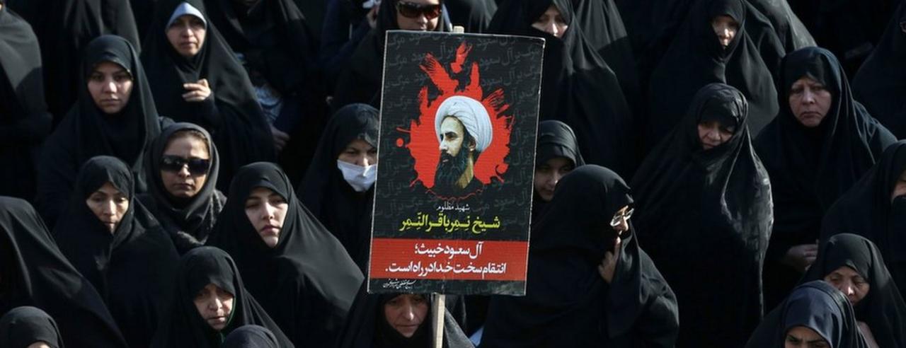 An Iranian woman holds up a poster showing Sheikh Nimr al-Nimr, a prominent opposition Saudi Shiite cleric who was executed last week by Saudi Arabia, in Tehran, Iran, Monday, Jan. 4, 2016.