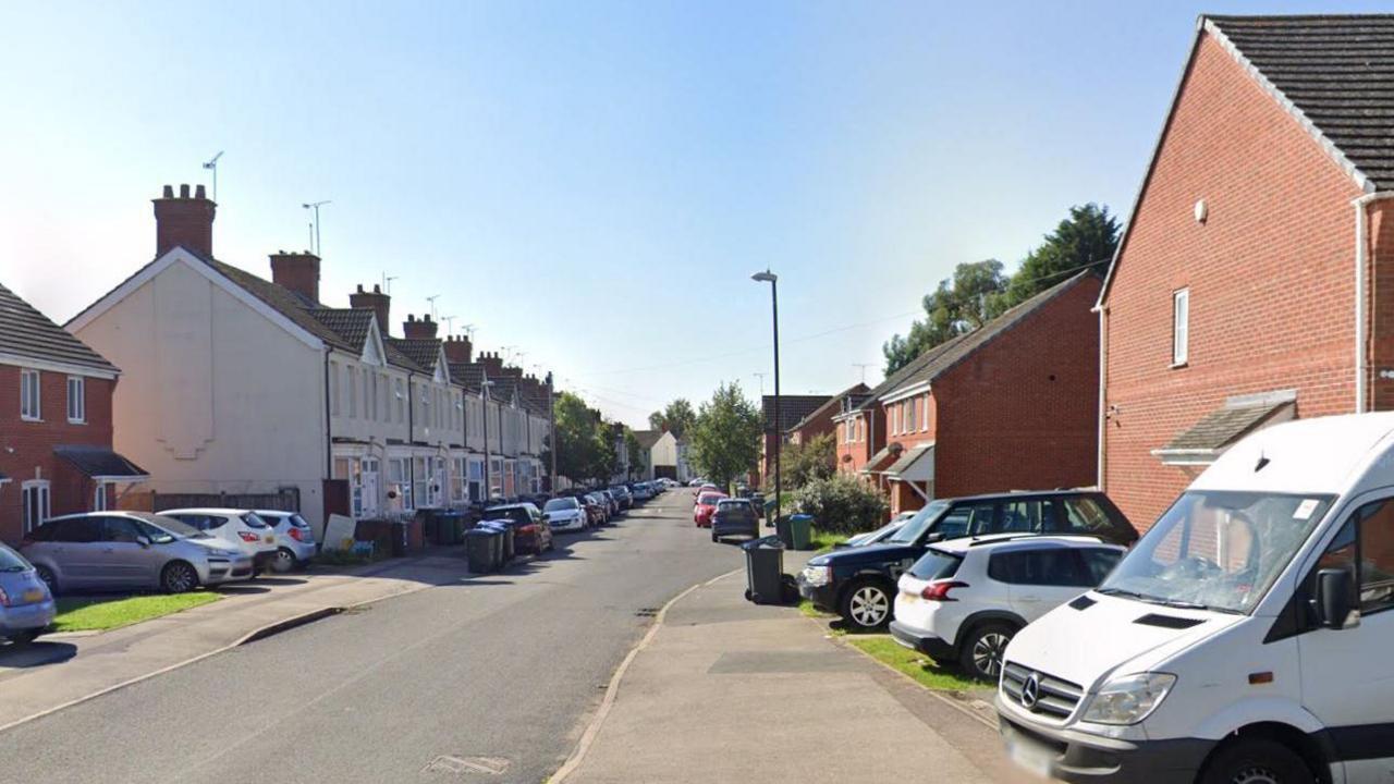 A Google maps street view of Guild Road in Coventry. It is a normal residential street with cars on driveways. 