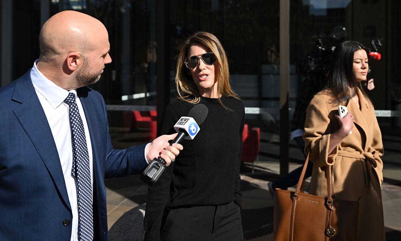 Giggle for Girls founder Sall Grover (centre) speaks into a microphone as she's approached by a reporter while leaving  the Federal Court of Australia in Sydney on 23 August