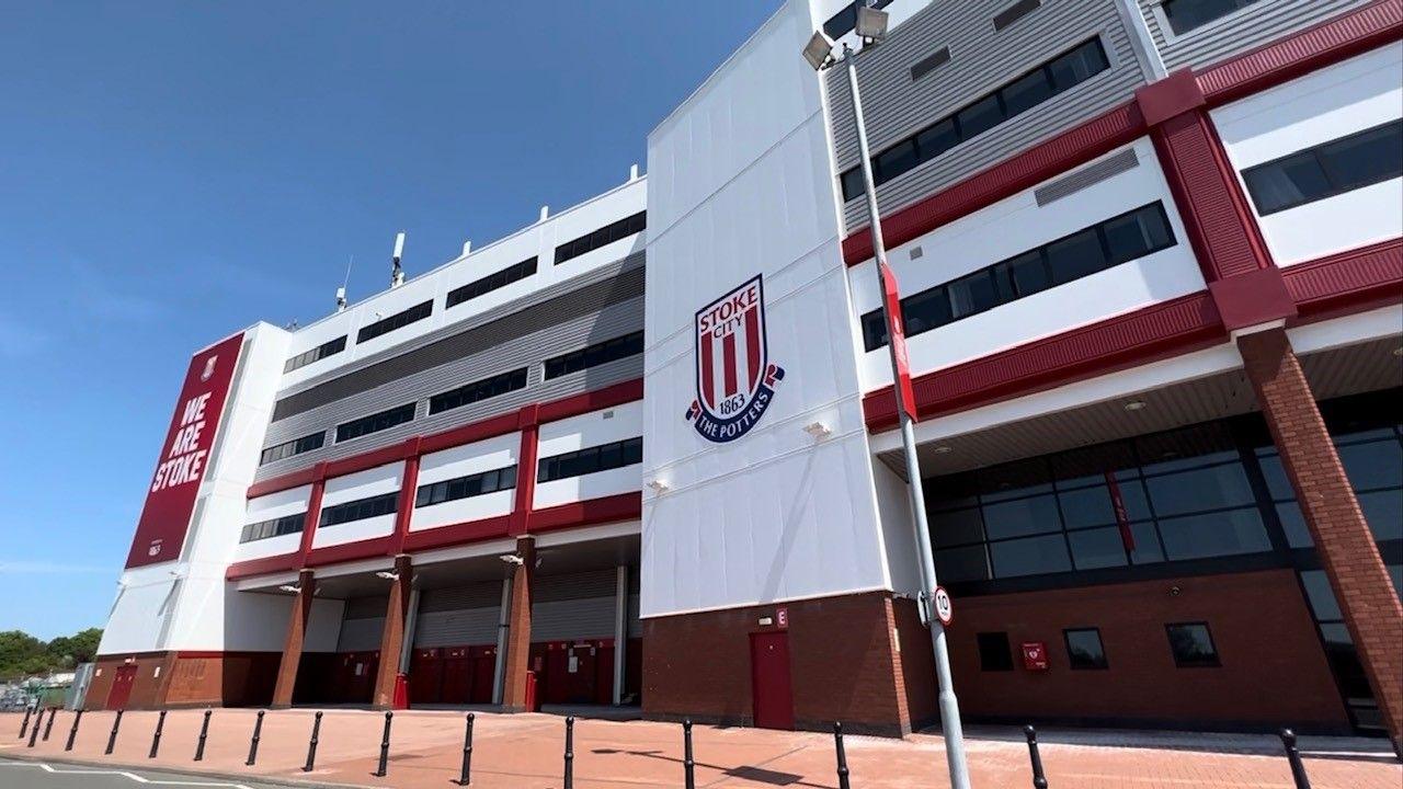 The exterior of the Stoke City football stadium, in the club's red and white branding 