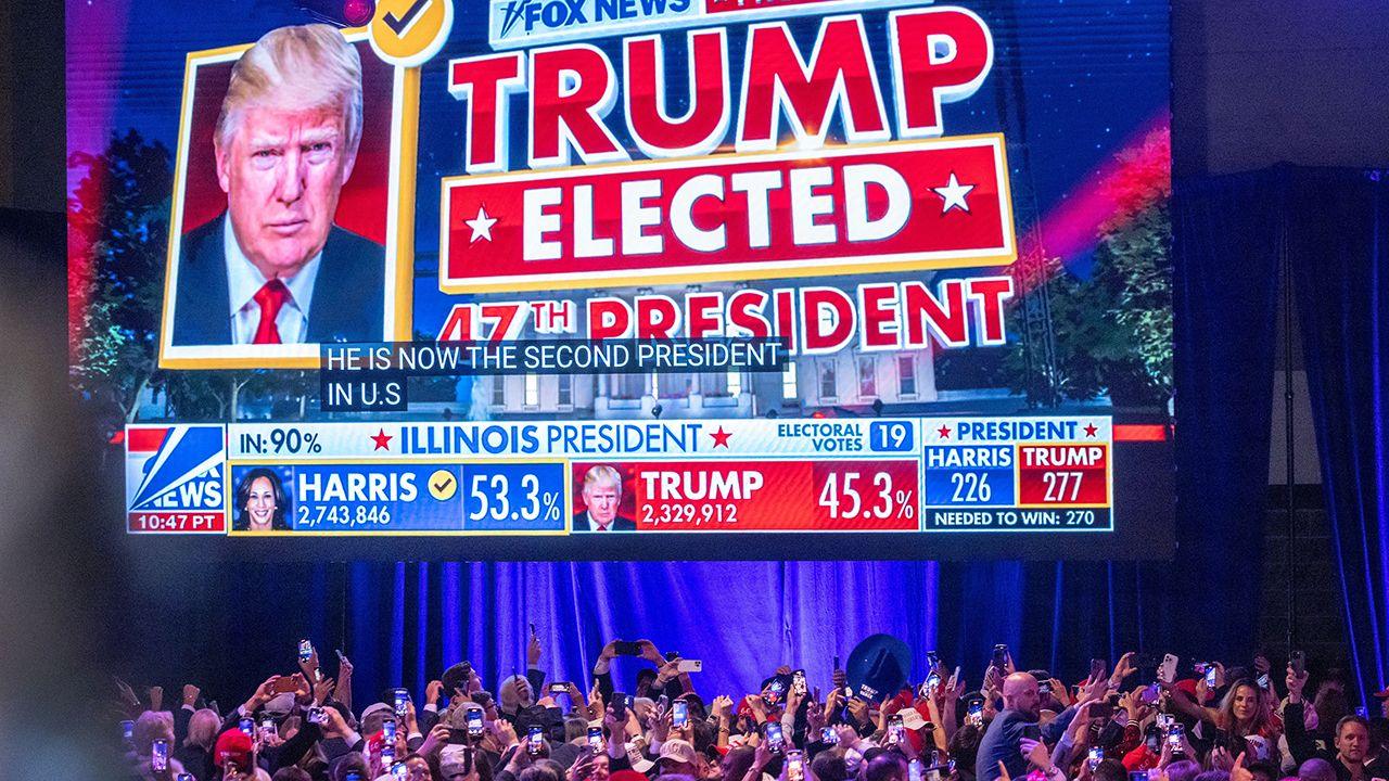 A screen displays Donald Trump's headshot and the words 'Trump elected 47th president' onstage in front of the crowd at the Republican election night watch party in Florida on 6 November