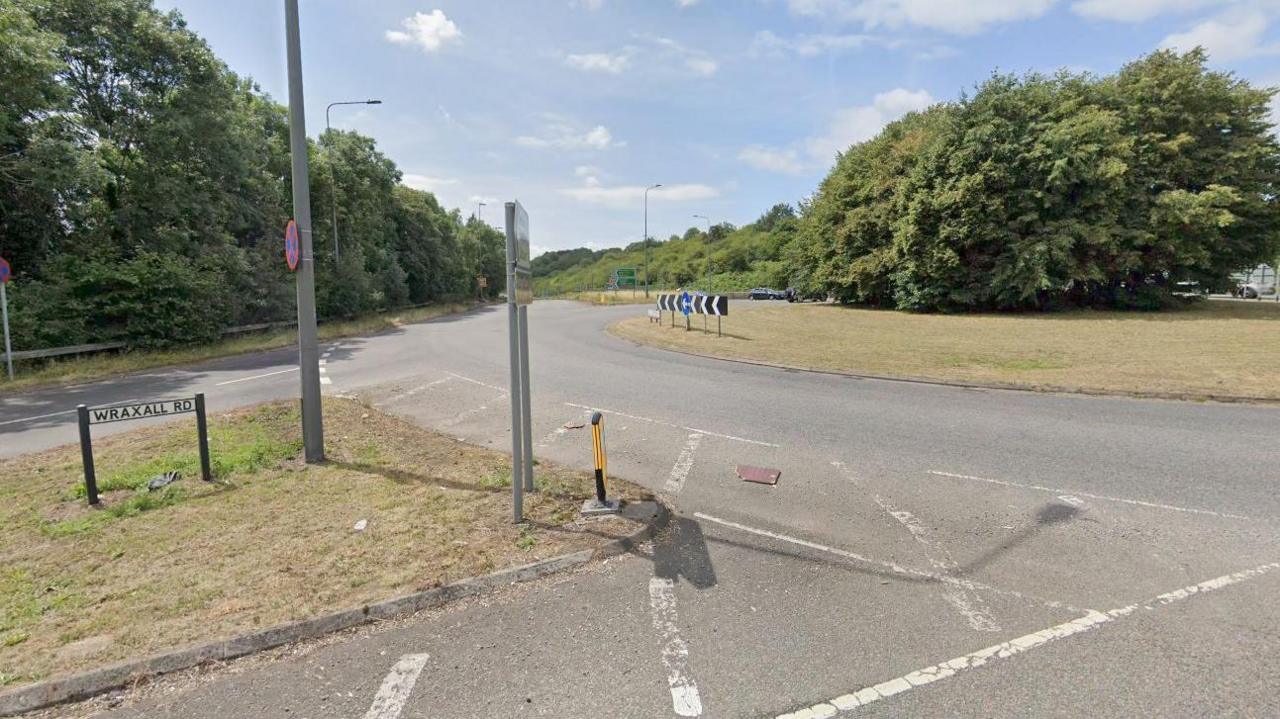 Wraxall Road roundabout in Warmley. It is a large roundabout with grass and a large tree in the middle