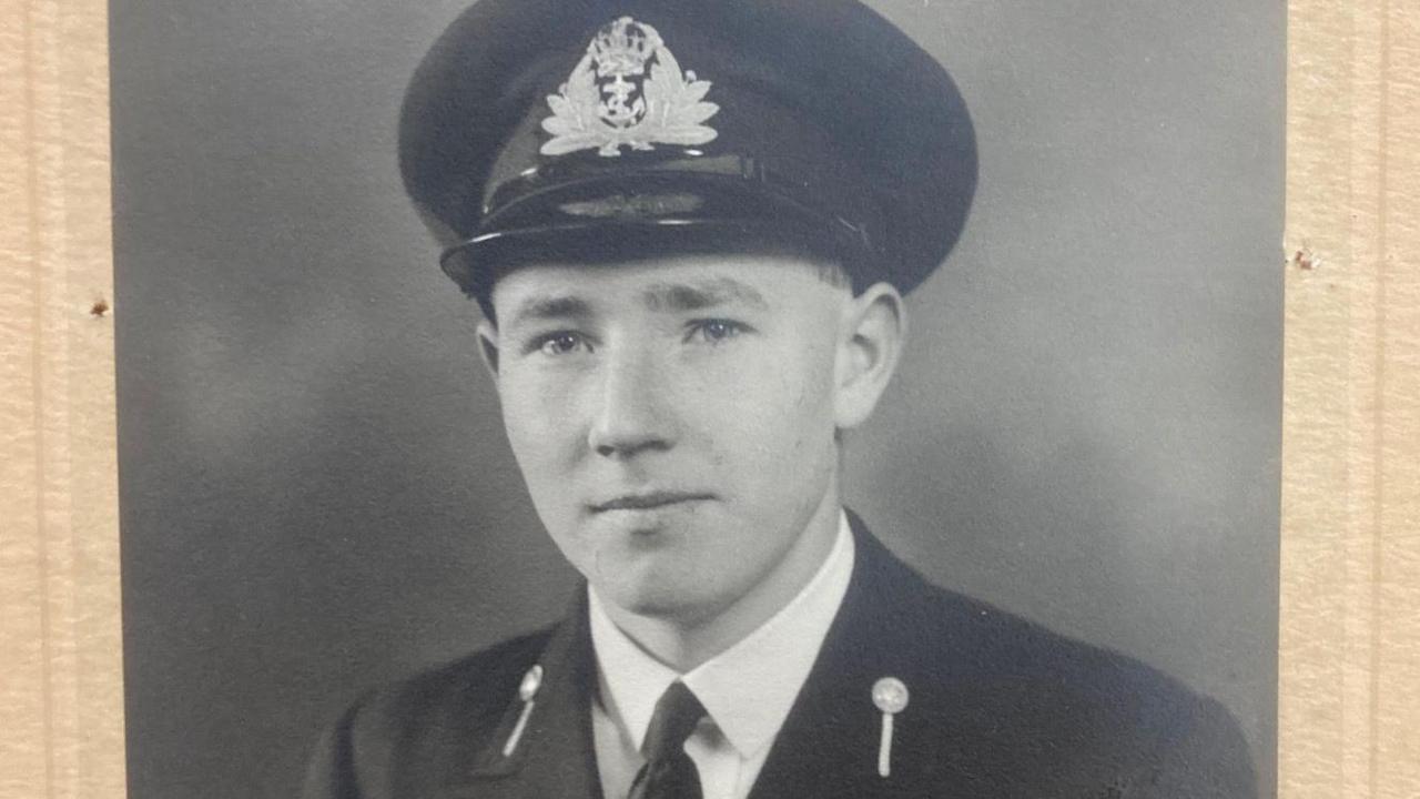 An old photograph of Douglas Parish during his days in the navy. He is wearing a naval uniform.