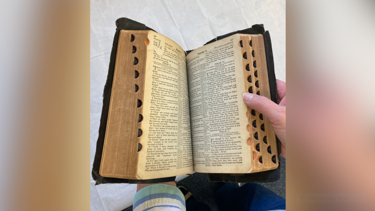Elvis Presley's bible being held open by female-looking hands.