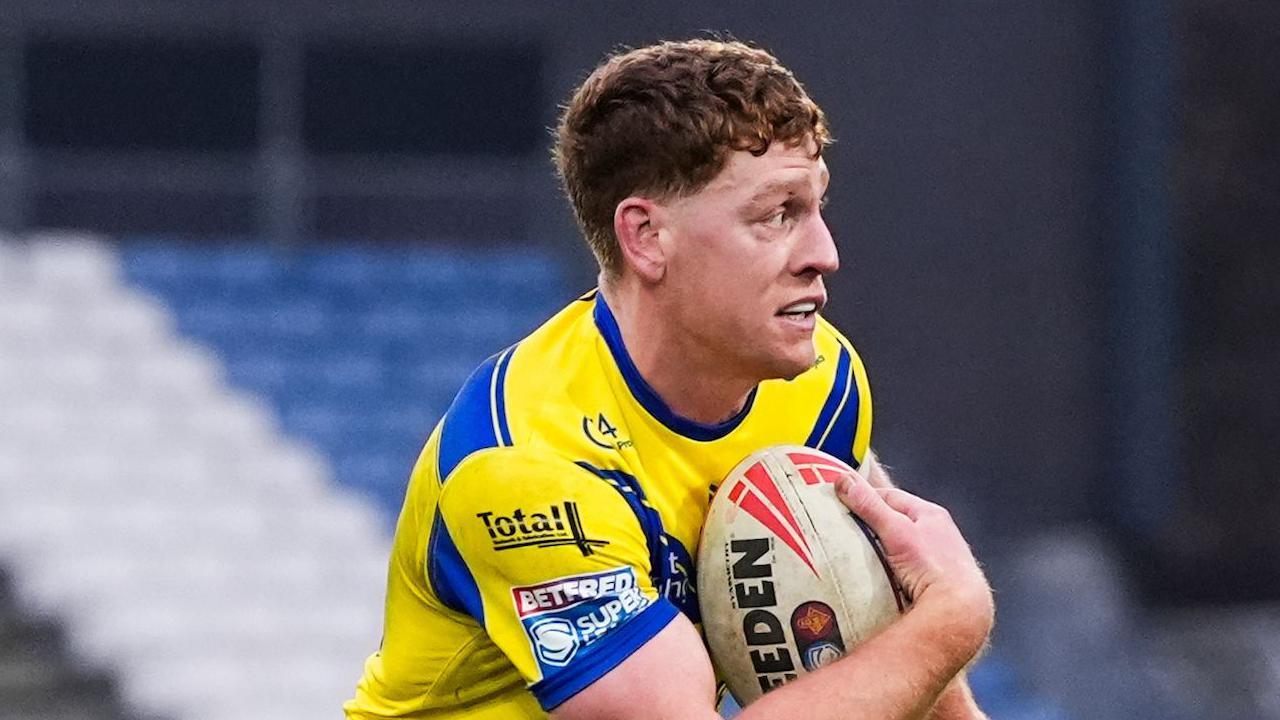Dan Russell with the ball under his right arm, during a match for Warrington in 2025