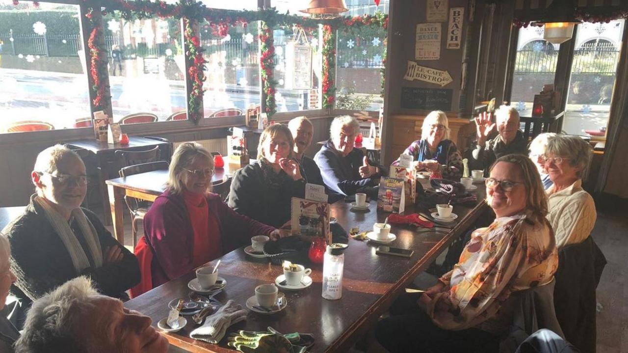 A group of beachcombers in The Netherlands sat around a table in a cafe