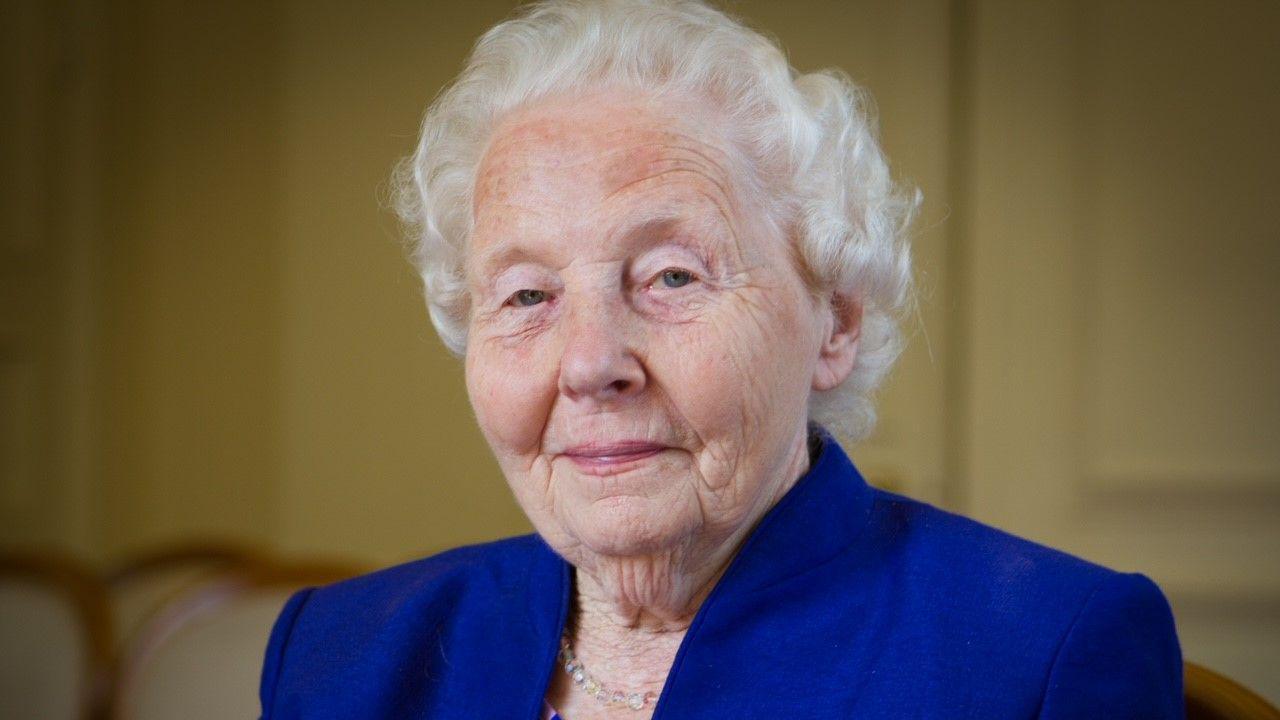 Joan Chapman, an elderly lady, looking towards the camera. She is wearing a blue jacket.