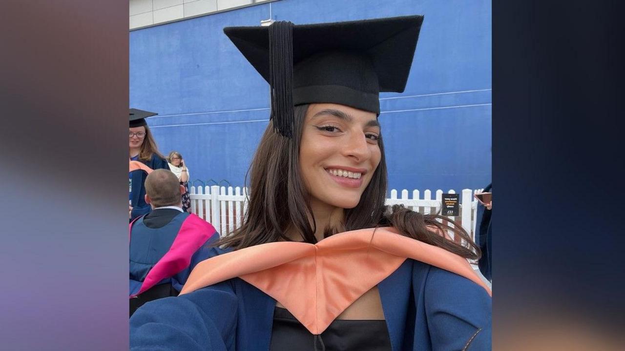 Buket Komur is wearing her university graduation mortar board and gown