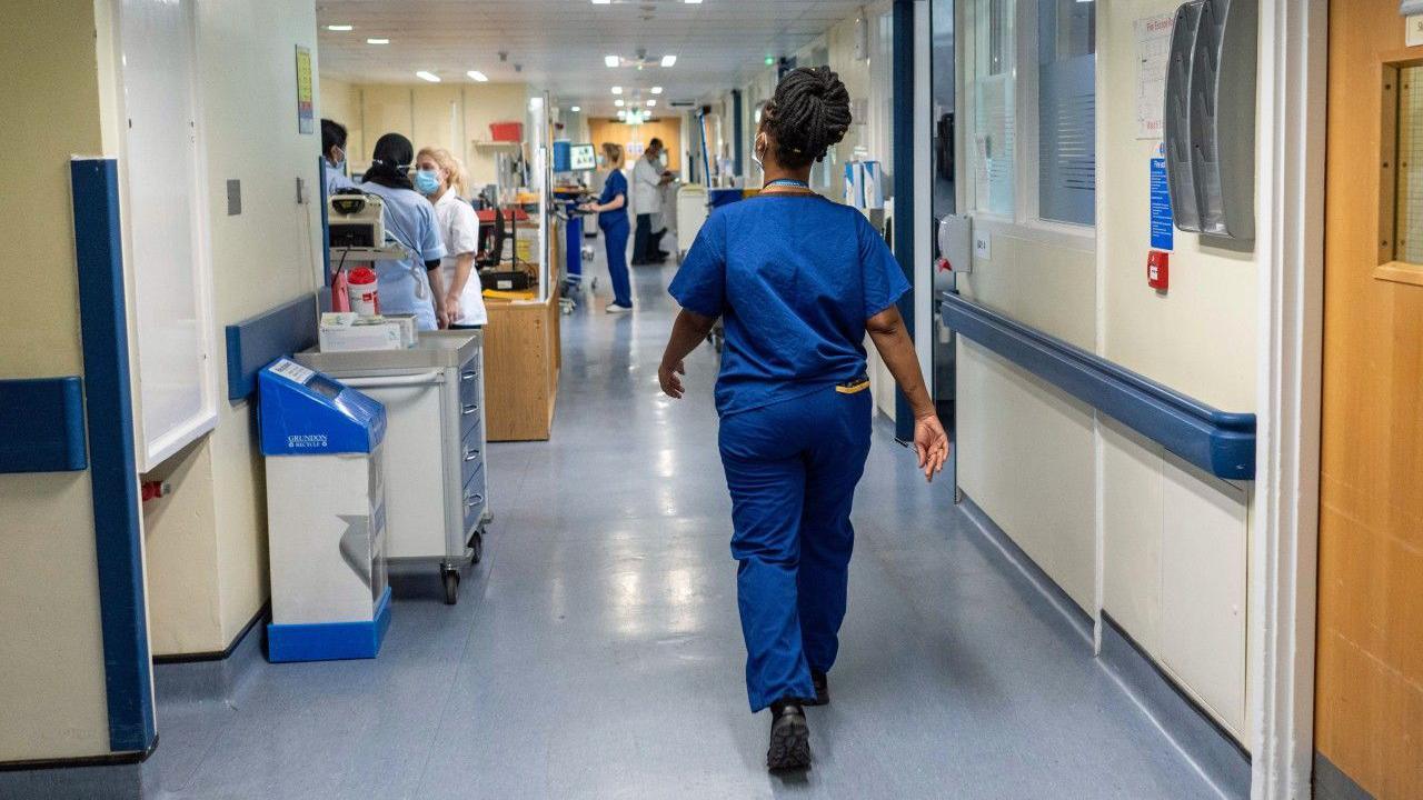 A nurse walking down a hospital corridor